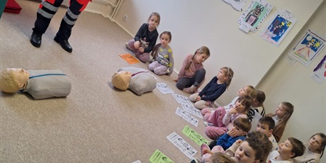 Powiększ grafikę: Dzieci klęczą przy manekinach i samodzielnie próbują udzielać pierwszej pomocy.