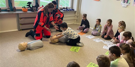 Powiększ grafikę: Dzieci klęczą przy manekinach i samodzielnie próbują udzielać pierwszej pomocy.