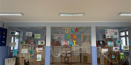 Powiększ grafikę: Kolorowe plakaty rozwieszone na siatce, zachęcające do  troski o czystą Ziemię.