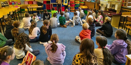 Powiększ grafikę: Dwóch chłopców stoi na tle granatowej tablicy z napisem KOCIEWIE.  Jeden chłopiec trzyma w rękach żóltą kartkę z herbem Skarszew, drugi chłopiec trzyma małą karteczkę, z której czyta informację o dany