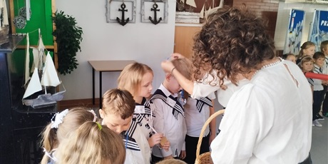 Powiększ grafikę: Nauczycielki rozdają medale uczniom upamiętniające pasowanie na zerówkowicza.