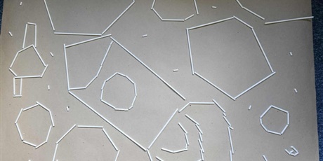 Powiększ grafikę: Na zdjęciu znajduje się plansza przedstawiająca kompozycję wykonaną z plastikowych patyków. Widać rakietę i planety.