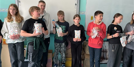 Powiększ grafikę: Uczestnicy konkursu z nagrodami w dłoniach stoją przy tablicy w sali 31.