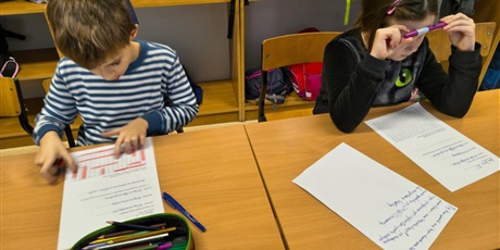 Powiększ grafikę: Dziewczynka i chłopiec siedzą przy stole i rozwiązują zadania dotyczące quizu wiedzy o kalendarzu.