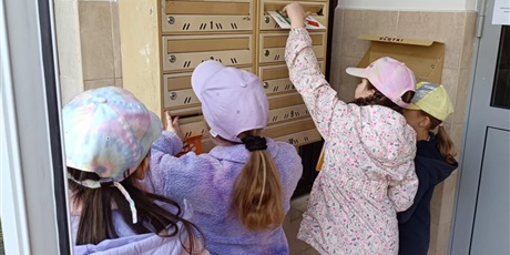 Powiększ grafikę: Cztery dziewczynki wrzucają kartki do skrzynek pocztowych. Na głowach mają czapki