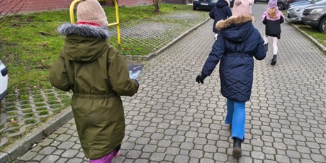 Powiększ grafikę: Cztery dziewczynki widoczne tyłem idą chodnikiem.