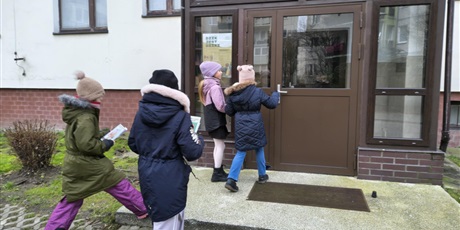 Powiększ grafikę: Cztery dziewczynki wchodzą do klatki. W rękach trzymają kartki.Cztery dziewczynki wchodzą do klatki. W rękach trzymają kartki.