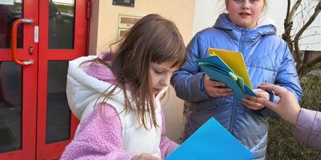 Powiększ grafikę: Dwie dziewczynki wyjmują kartki wielkanocne z białego pudełka.