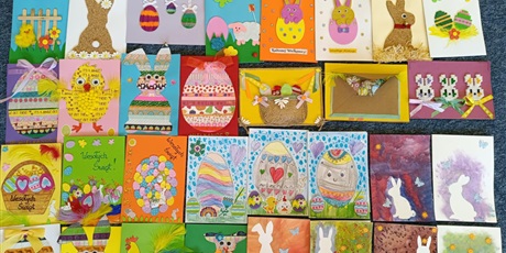 Powiększ grafikę: Kilkadziesiąt prostokątnych kartek wielkanocnych ułożonych obok siebie.