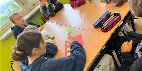 Powiększ grafikę: Dzieci siedzą przy stolikach i pracują w grupie.