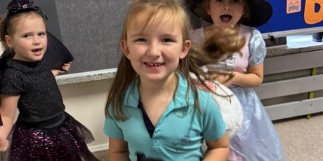 Powiększ grafikę: Dziewczynki przebrane za postacie z bajek tańczą i się śmieją.