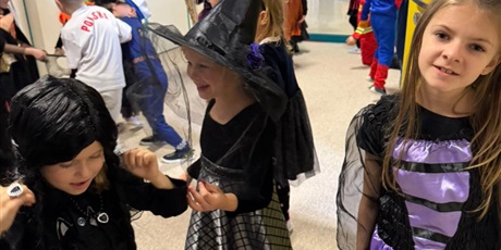 Powiększ grafikę: Dziewczynki przebrane za postacie z bajek tańczą i się śmieją. 