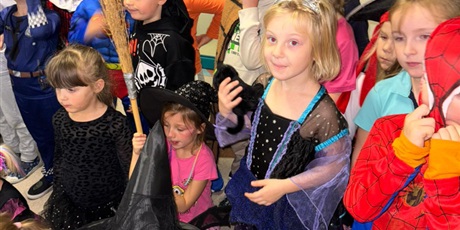 Powiększ grafikę: Grupa dzieci przebranych na postacie z bajek słuchają opowieści.