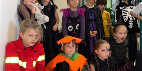 Powiększ grafikę: Grupa przebranych w stronie dzieci słucha opowieści.