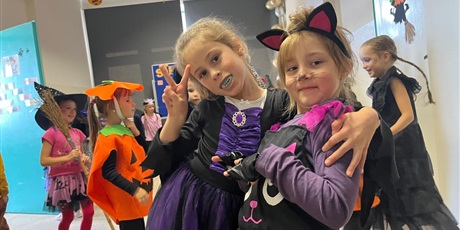 Powiększ grafikę: Przebrane dziewczynki pozują do zdjęcia. Możemy zobaczyć Wednesday  oraz kotkę