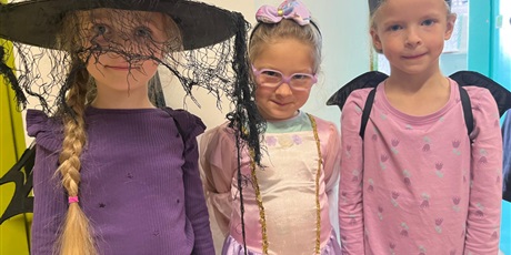 Powiększ grafikę: Trzy dziewczynki pozują do zdjecia. Pokazują swoje przebrania.