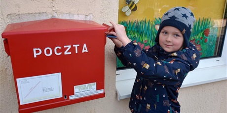 Powiększ grafikę: Dziecko wrzuca kartkę do skrzynki pocztowej.