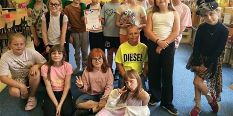 Powiększ grafikę: Grupa dzieci pozuje do zdjęcia. W rękach trzymają dyplom i worek ze słodyczami.