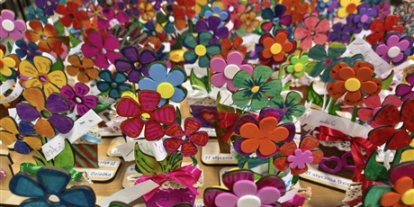 Powiększ grafikę: Na stole stoją kolorowe kwiatki przygotowane przez dzieci z okazji Dnia Babci i Dziadka.