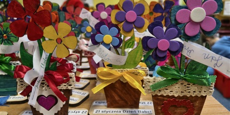 Powiększ grafikę: Na stole stoją kolorowe kwiatki przygotowane przez dzieci z okazji Dnia Babci i Dziadka.