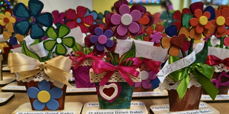 Powiększ grafikę: Na stole stoją kolorowe kwiatki przygotowane przez dzieci z okazji Dnia Babci i Dziadka.