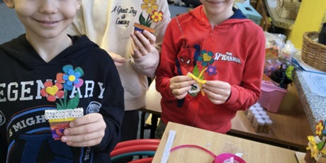 Powiększ grafikę: Trzech chłopców pozuje do zdjęcia. W rękach trzymają wykonane przez siebie kolorowe kwiatki, które wykonali dla swoich dziadków.