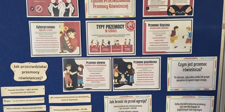 Powiększ grafikę:  Granatowa tablica zawierająca informacje o przeciwdziałaniu przemocy rówieśniczej.