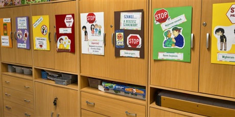 Powiększ grafikę: Na szafkach wiszą plakaty  wykonane przez dzieci. Zawierają one  treści informujące o przeciwdziałaniu przemocy rówieśniczej.