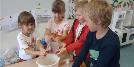 Powiększ grafikę: Grupa dzieci w misce pierze ubrania.