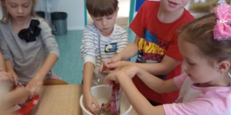 Powiększ grafikę: Grupa dzieci w misce pierze ubrania.