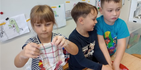 Powiększ grafikę: Grupa dzieci w misce pierze ubrania.