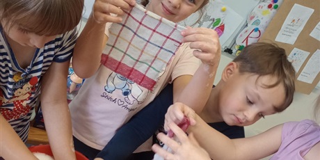 Powiększ grafikę: Dziewczynka pokazuje wypraną ściereczkę. Cieszy się z wykonanej pracy.