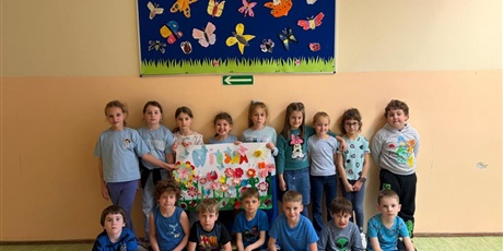 Powiększ grafikę: 4.	Radosne dzieci trzymają plakat, na którym widać różnokolorowe motyle i kwiaty.