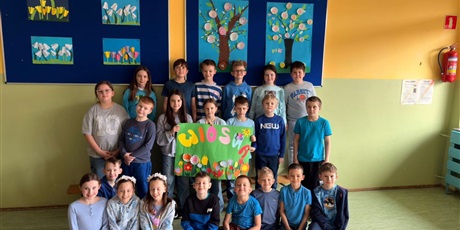 Powiększ grafikę: 11.	Uczniowie trzymają cztery plakaty wiosenne oraz litery, które tworzą napis wiosna.