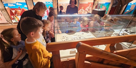 Powiększ grafikę: Grupa dzieci 6-letnich ogląda eksponaty znajdujące się w muzeum.