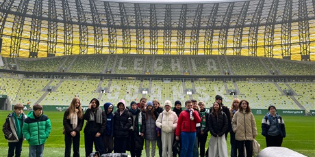 Powiększ grafikę: Klasa 6b na stadionie Polsat Plus Arena. Dzieci znajdują się na murawie wewnątrz stadionu.