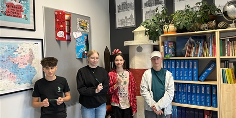 Powiększ grafikę: Grupa uczniów pozduje do zdjęcia. W rękach trzymają długopisy.