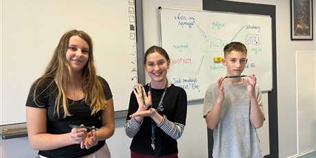 Powiększ grafikę: Uczniowie pozdją do zdjęcia. Pokazują otrzymane długopisy.