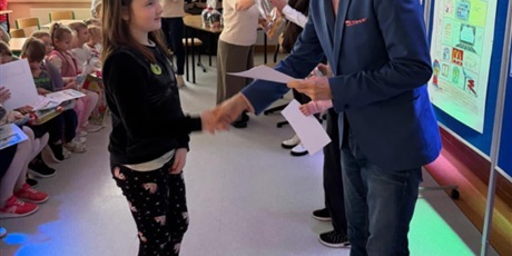 Powiększ grafikę: Dziewczynka odbiera dyplom od dyrektora szkoły za udział w konkursie "Szkoła moich marzeń".