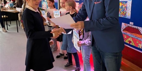 Powiększ grafikę: Dziewczynka odbiera dyplom od dyrektora szkoły za udział w konkursie "Szkoła moich marzeń".